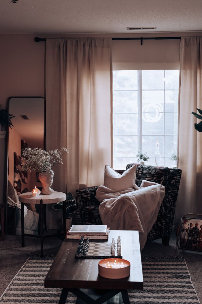 The Art of Drawing Readers In: Your attractive post title goes here A stylish and cozy living room interior with warm lighting, featuring a wicker armchair and decorative elements.